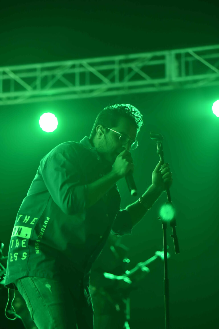 Singer performing under green lights at Circle Club