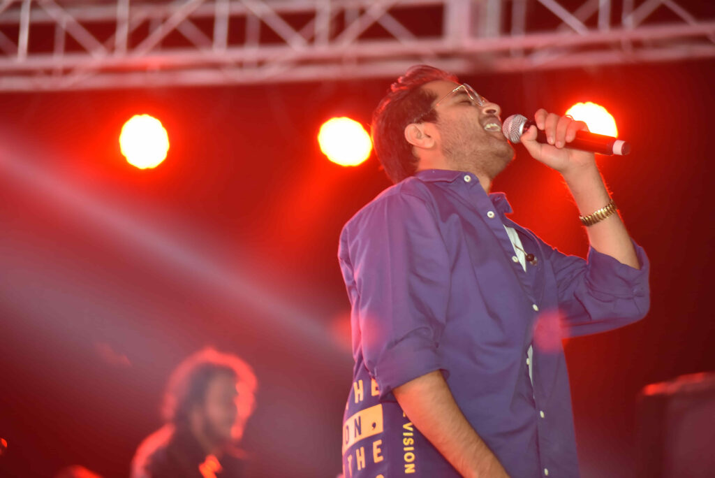 Vocalist performing under red stage lights