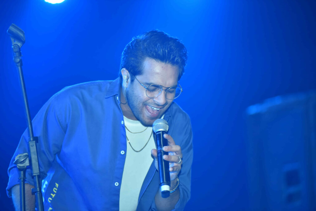 Singer performing beneath blue lights